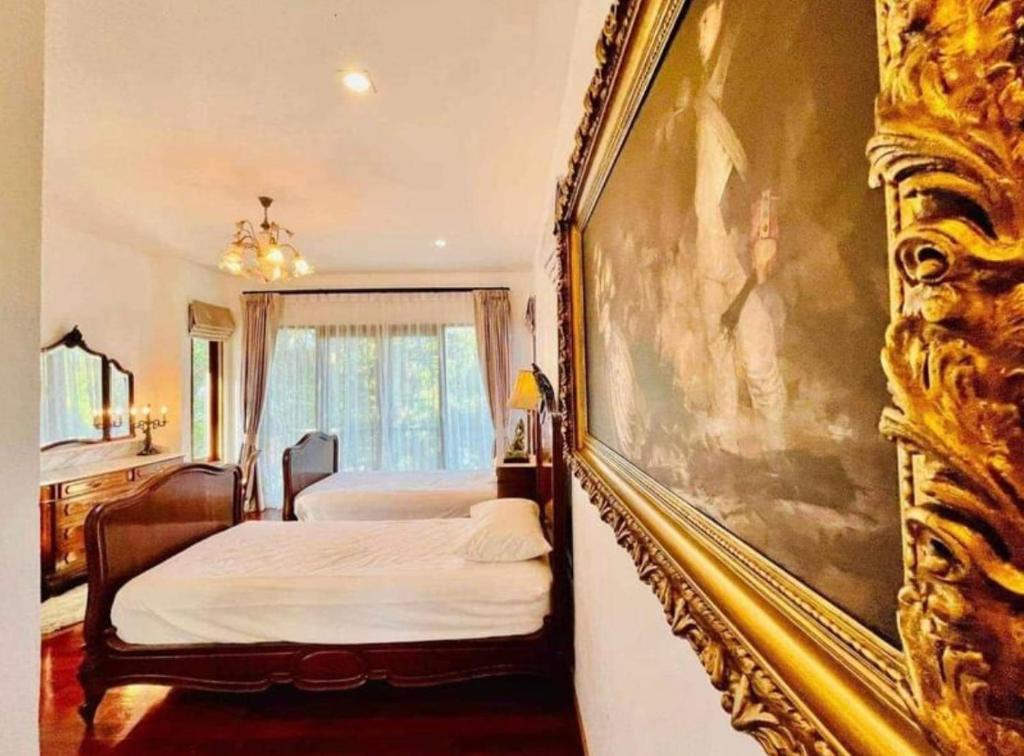 ein Schlafzimmer mit 2 Betten und einem Wandgemälde in der Unterkunft Cozy house with 3 big bedrooms in Ban Suan