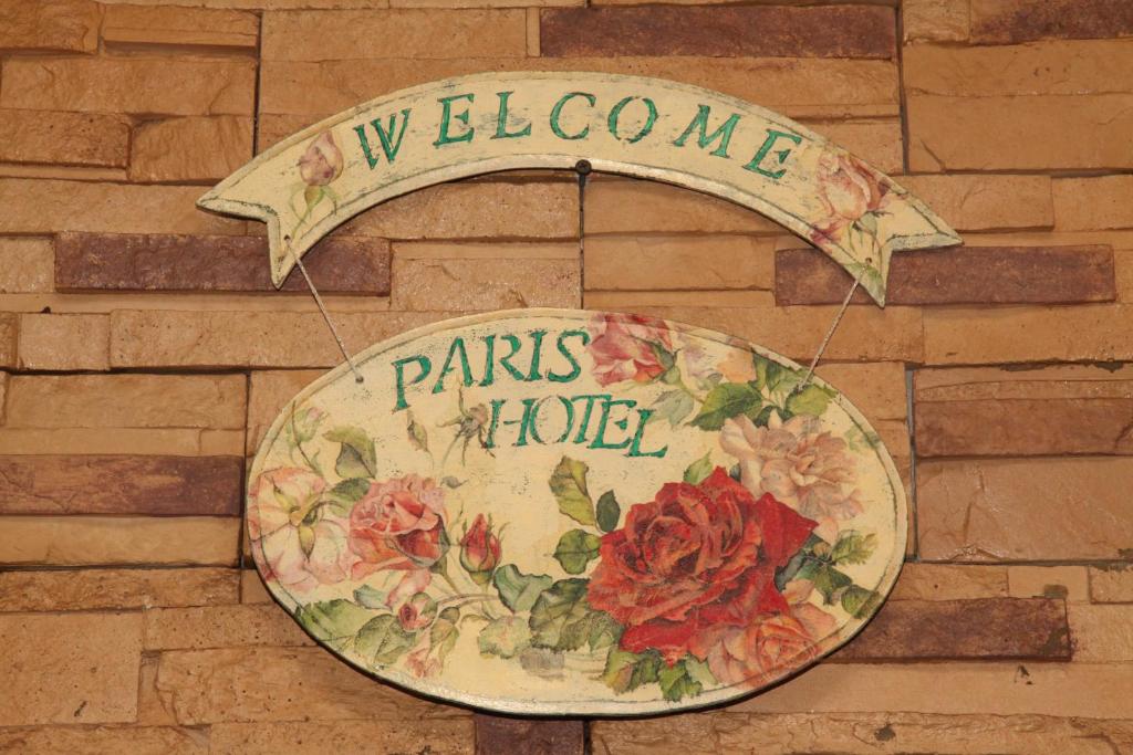 un panneau sur un mur avec des fleurs sur lui dans l'établissement Paris Hotel, à Xánthi