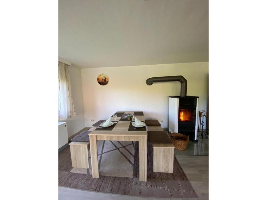 a wooden table in a room with a fireplace at Ferienwohnung am Südhang in Gernsbach