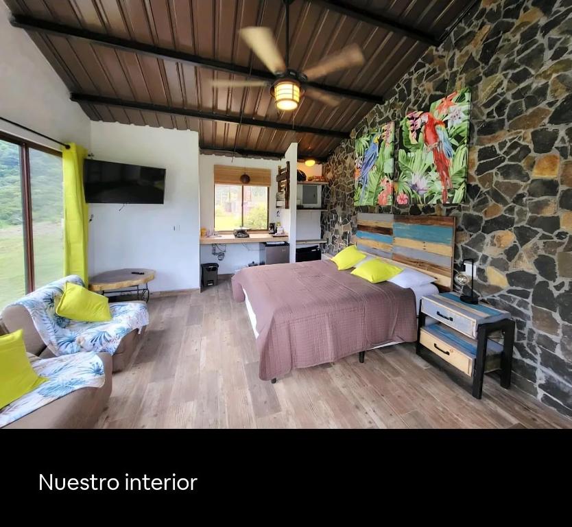 um quarto com uma cama e uma parede de pedra em Pika Cabins 1 em San Carlos