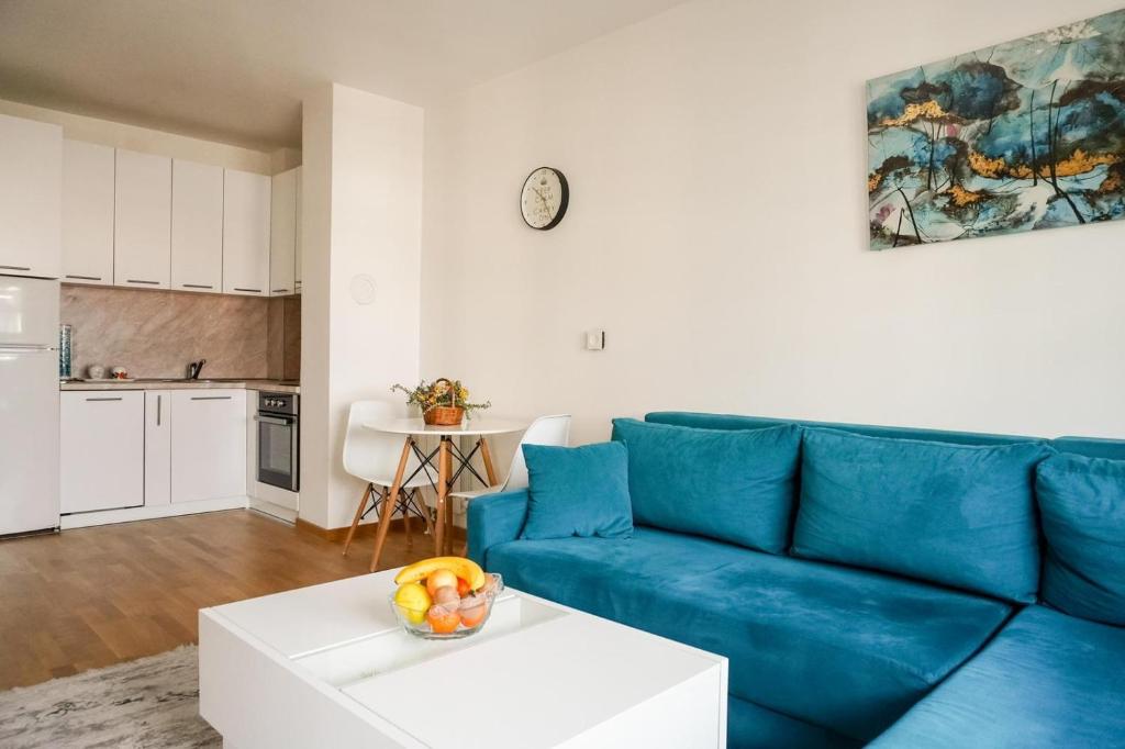 a living room with a blue couch and a table at Apartman “Ada” in Sarajevo