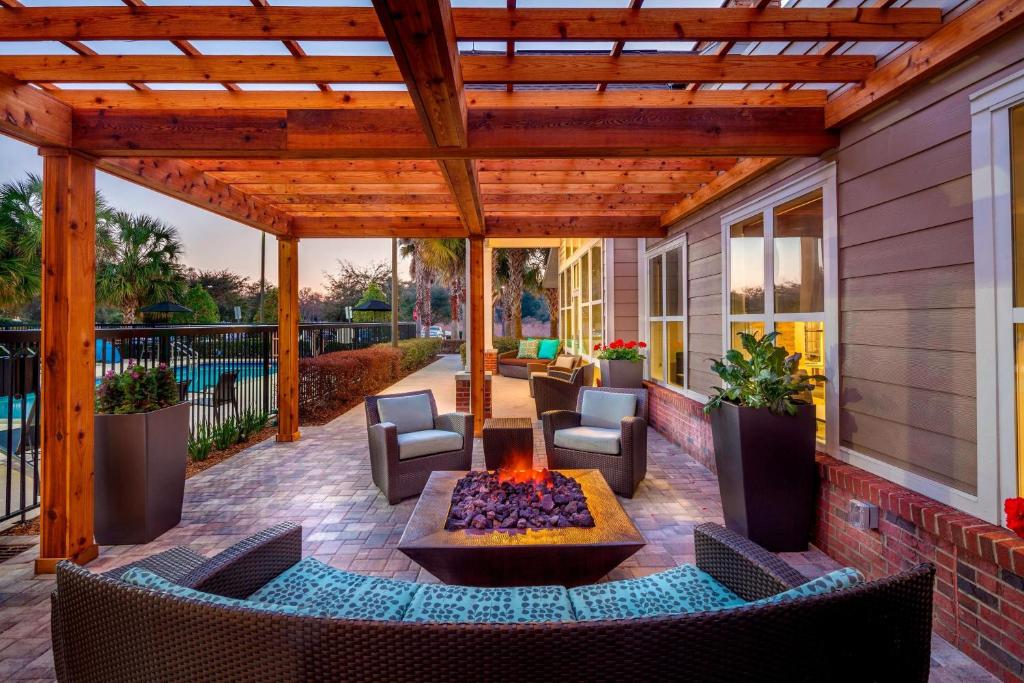 un patio al aire libre con una hoguera y una pérgola de madera en Residence Inn Ocala, en Ocala