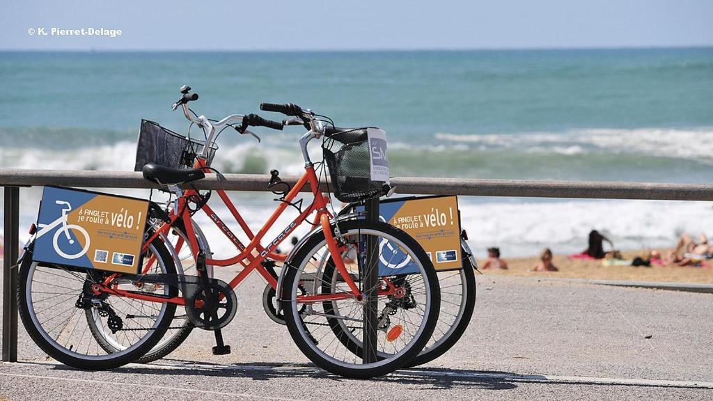 un vélo garé à côté d'une clôture à la plage dans l'établissement COSY ROOM PRIVATE BATH AND GARDEN, à Anglet