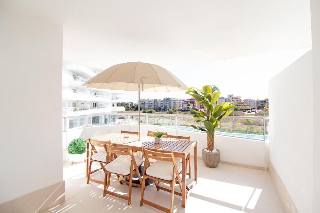 uma mesa e cadeiras com um guarda-sol numa varanda em Global Properties, Apartamento con 2 terrazas en Gran Canet em Canet d'En Berenguer