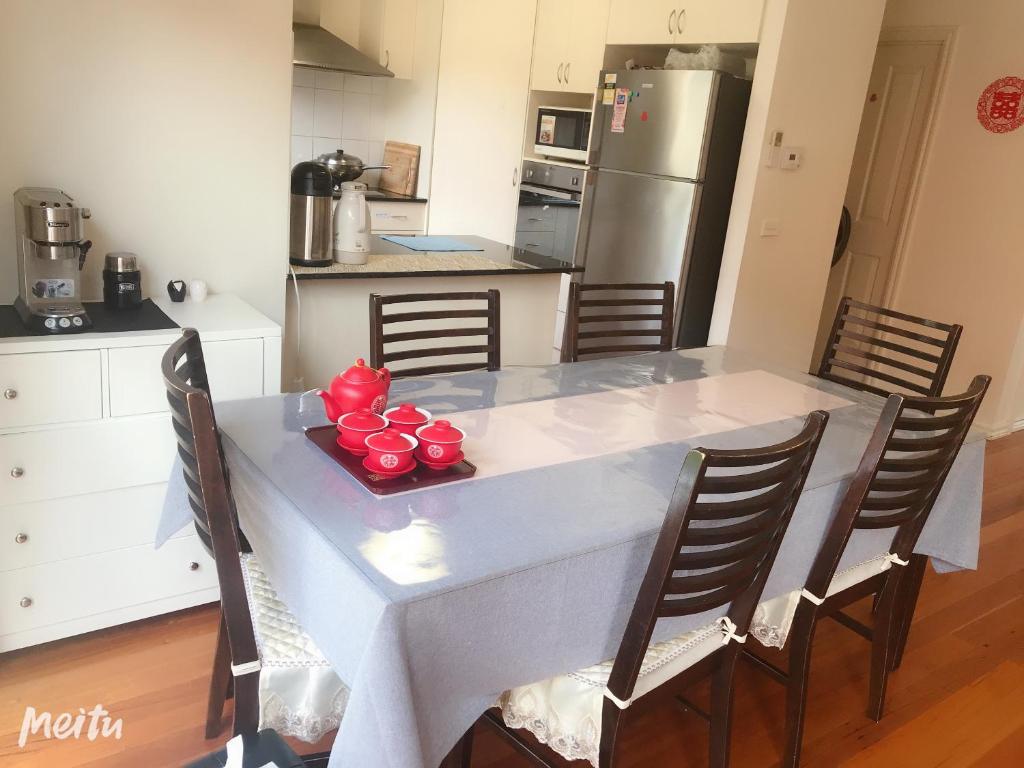 una cucina con tavolo e ciotole rosse di Tina house a Springvale