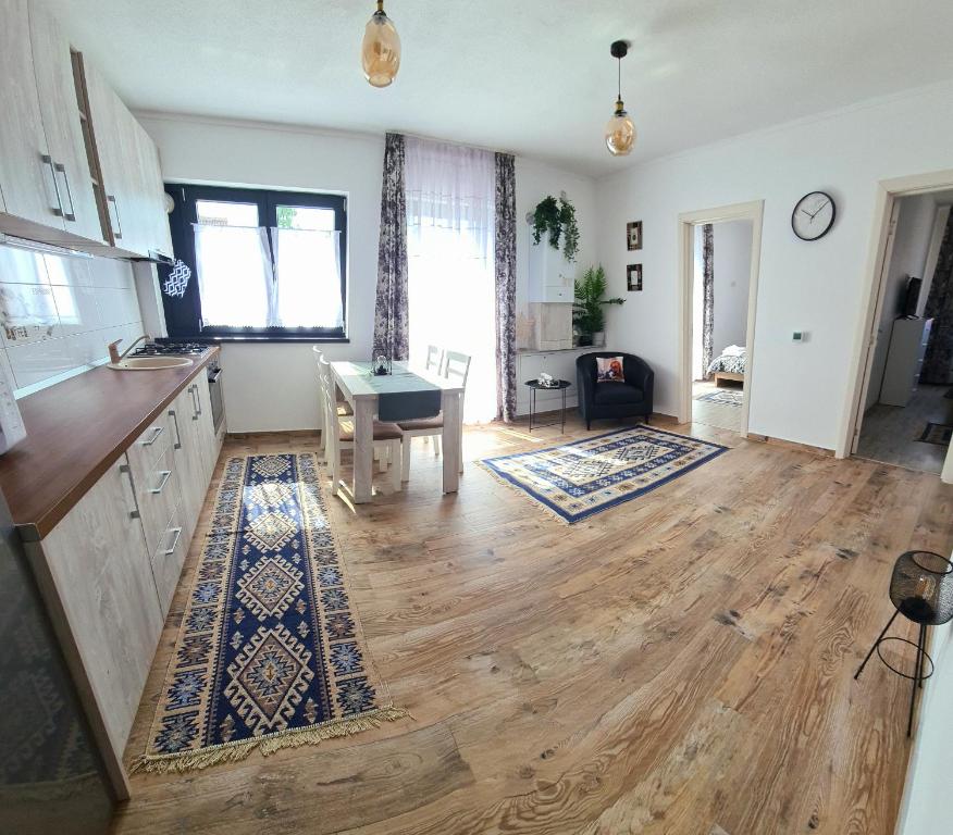 a kitchen with a wooden floor and a table at Apartament Eminescu in Zărneşti