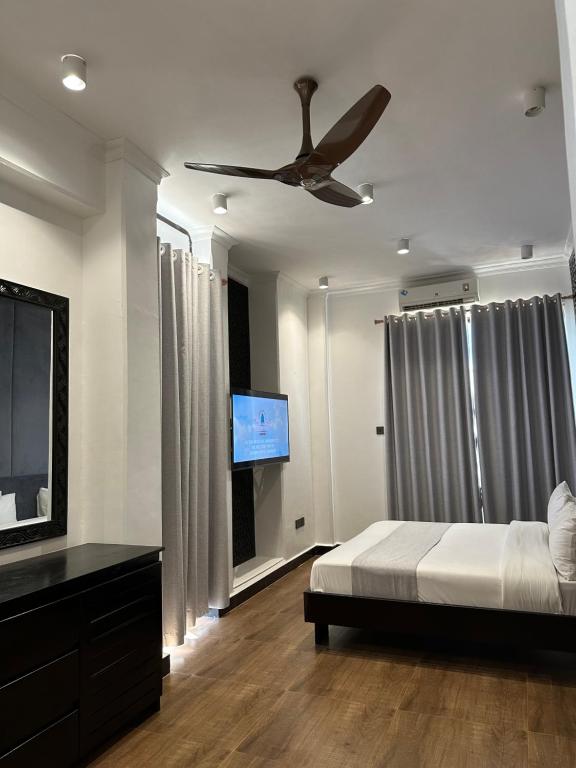 a bedroom with a bed and a flat screen tv at Dreams Hotel Zanzibar in Zanzibar City