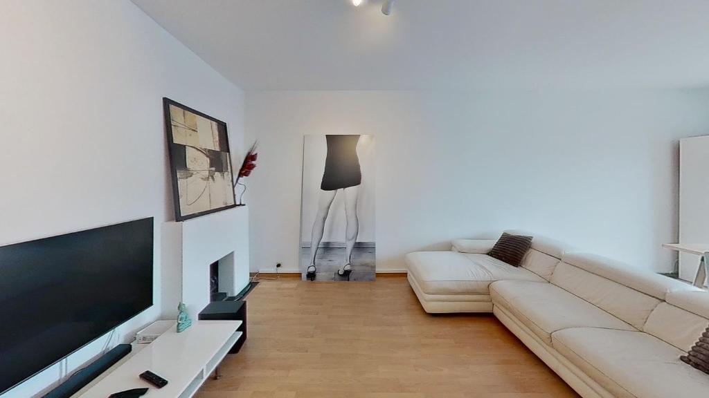 a living room with a couch and a flat screen tv at nice and cosy apartment in Edegem