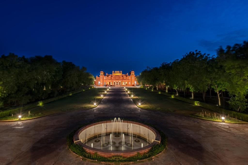 - un grand bâtiment avec une fontaine devant lui la nuit dans l'établissement Brij Gaj Kesri, Bikaner - A Boutique Luxury Palace, à Bikaner
