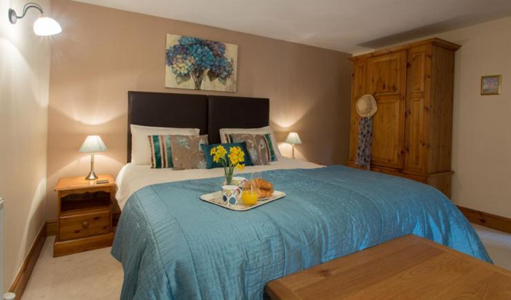 um quarto com uma cama com uma bandeja com flores em Wheal Kitty nr Truro em Truro