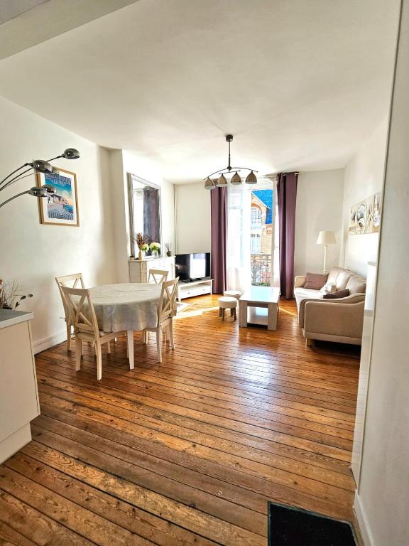 un salon avec une table, des chaises et un canapé dans l'établissement Appartement douillet en hyper centre de Dieppe, à Dieppe