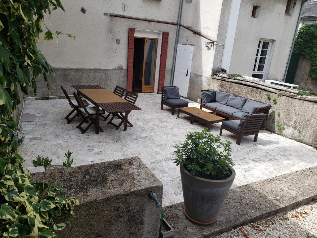 a patio with chairs and a table and a couch at Gite PASSIFLORE in Cour-Cheverny