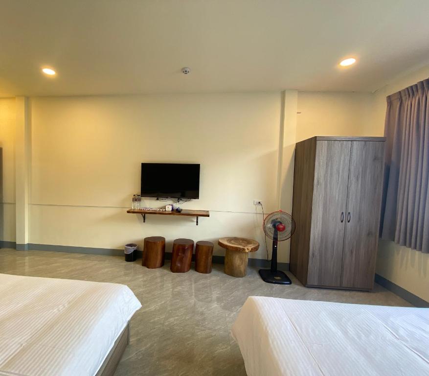 a bedroom with two beds and a flat screen tv at 亞士密民宿 in Puli