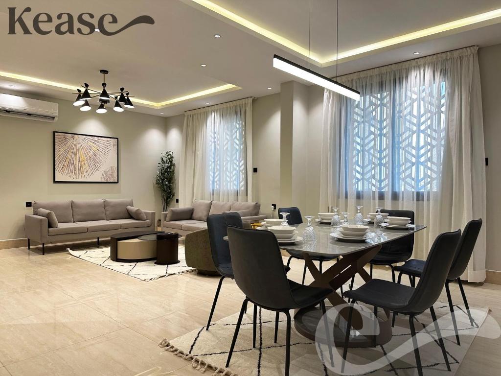 a dining room with a table and a living room at Kease Malqa B-4 Royal Touch AZ31 in Riyadh