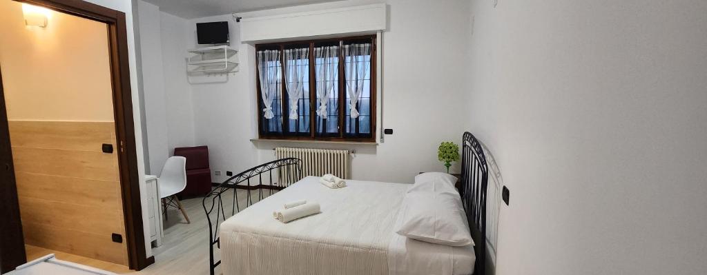 a bedroom with a bed and a table and a window at DORMI DA ME DORMI DA RE in Amandola