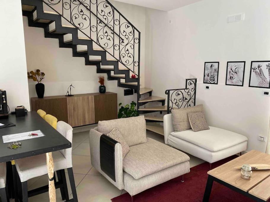 - un salon avec deux chaises et un escalier dans l'établissement “Salotto Miano” - Intero Appartamento Arredato, à Pomigliano dʼArco