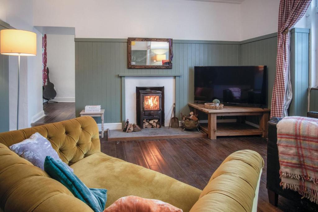 a living room with a couch and a fireplace at Melbourne Cottage - 3 Bedroom Cottage - Pembroke in Pembroke