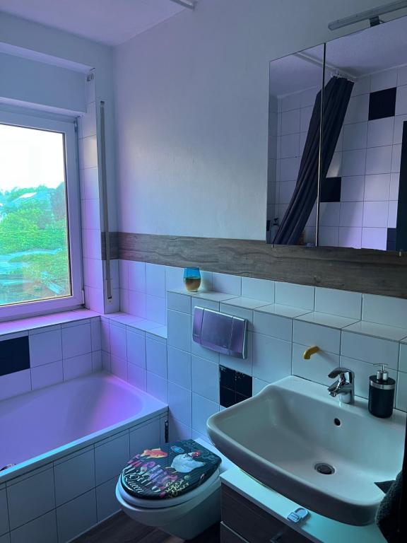 La salle de bains est pourvue d'un lavabo, de toilettes et d'une baignoire. dans l'établissement Zimmer Nähe Darmstadt, à Roßdorf