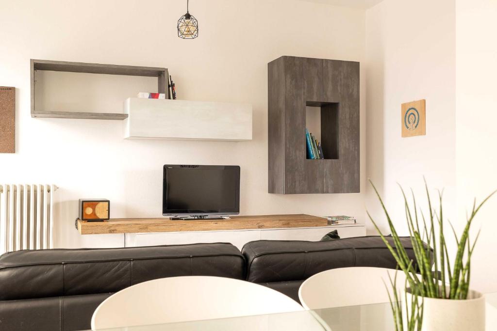 a living room with a black couch and a tv at Spazio Ancora appartamento a 500 m. dal mare in Rimini