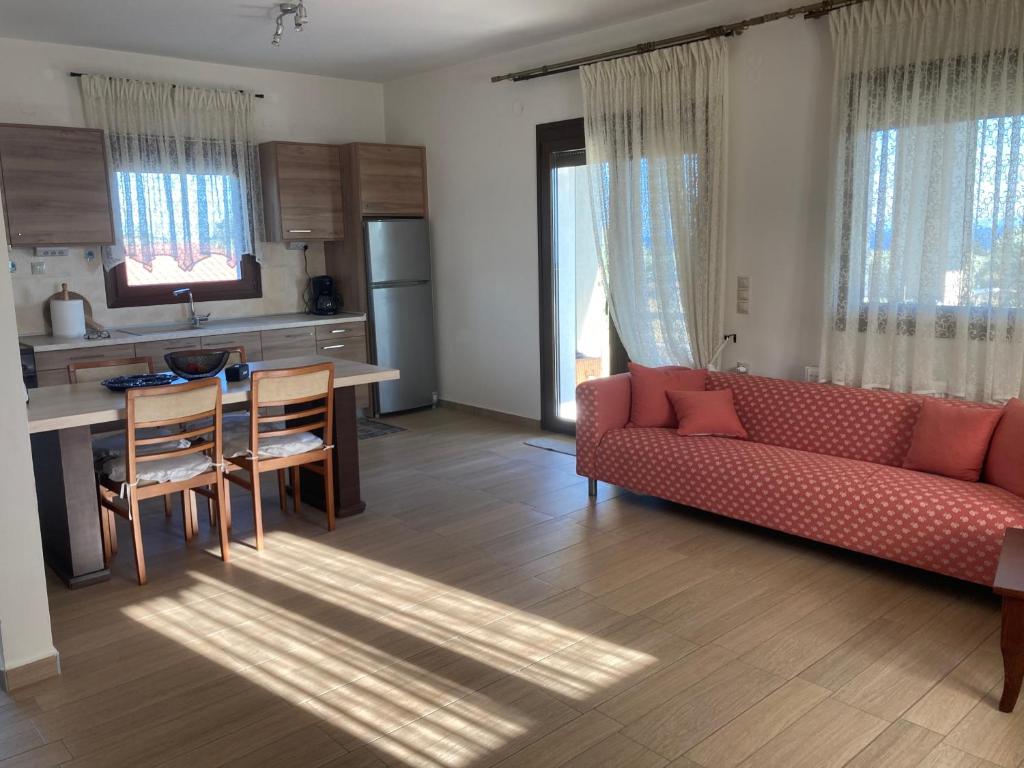 a living room with a red couch and a table at Villa Giannoula in Gerakini