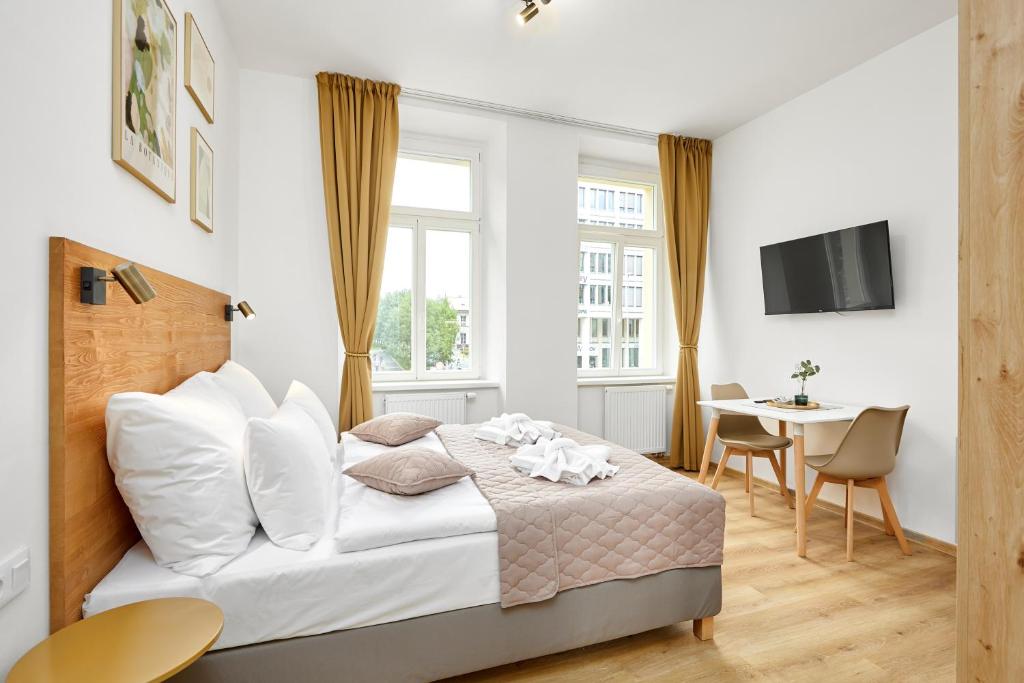 Residence 44 في براغ: غرفة نوم بيضاء مع سرير وطاولة