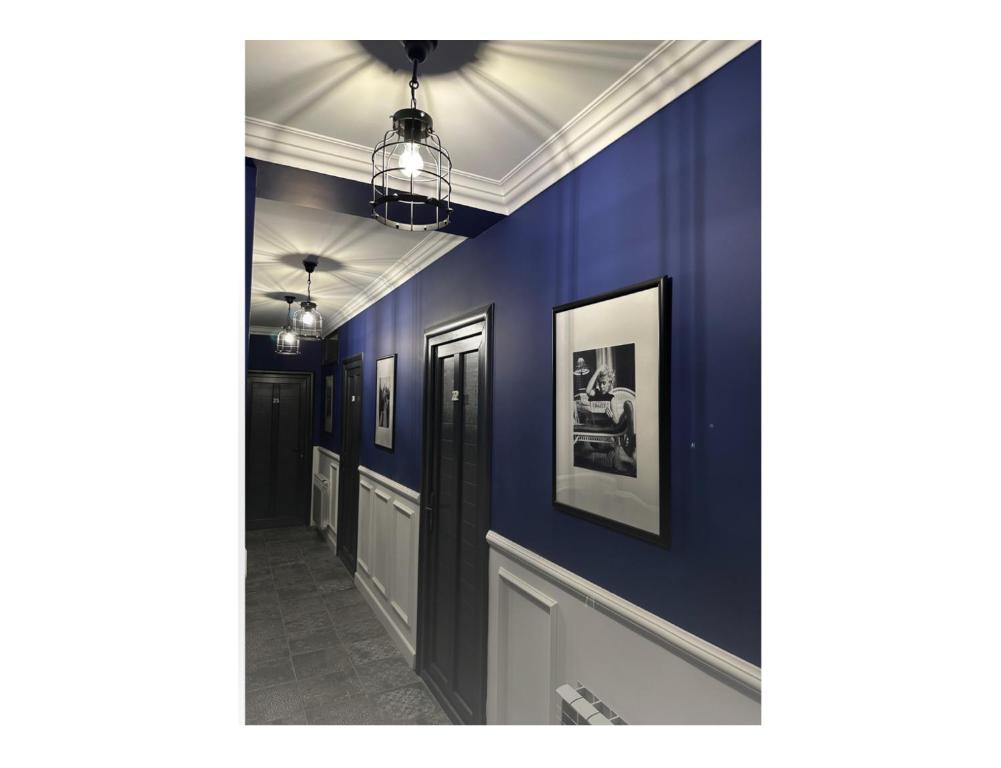 einen Flur mit blauen Wänden und Bildern an der Wand in der Unterkunft Avalon Hotel Armenia in Yerevan