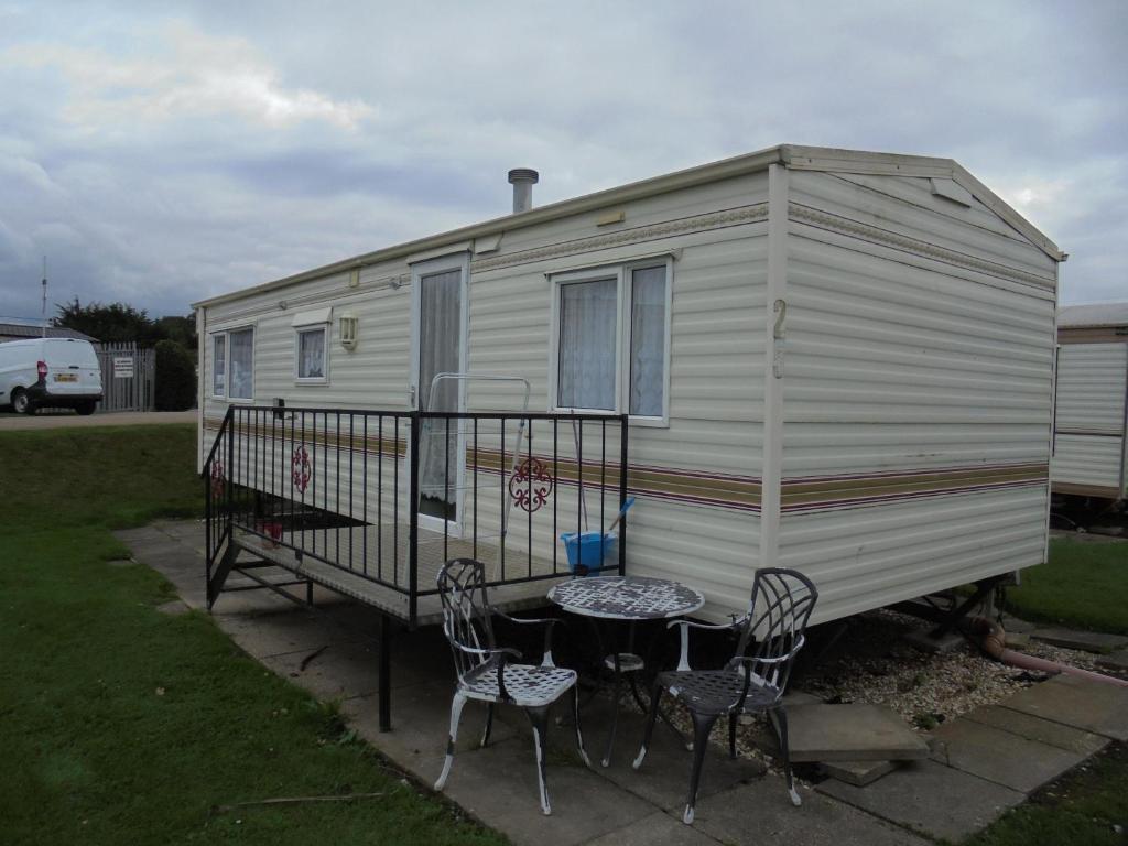 a white rv with a table and chairs at Sealands : Arronbrook:- 6 Berth, Access to the beach, Close to site entrance in Ingoldmells