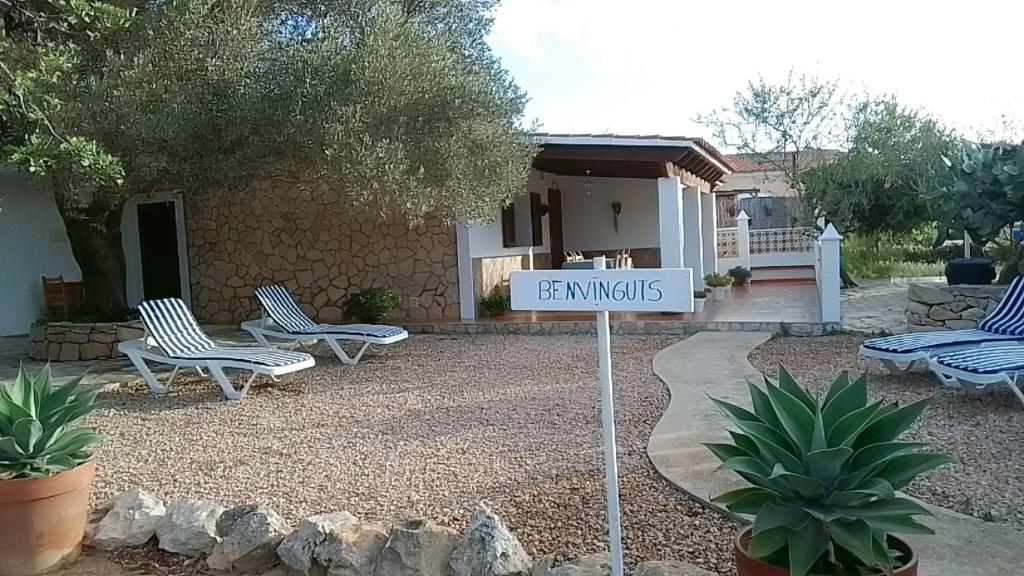 ein Schild in einem Hof mit zwei Stühlen und einem Haus in der Unterkunft Casa Pamela in Cala Saona
