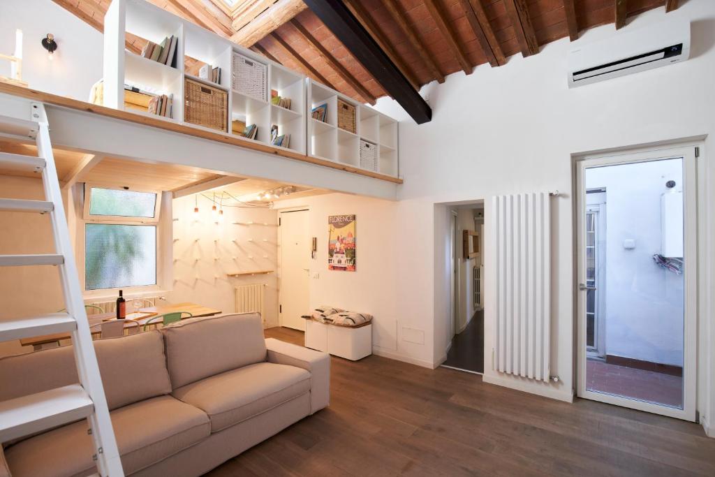 salon z łóżkiem na podwyższeniu i kanapą w obiekcie The Chianti Rooster Flat we Florencji
