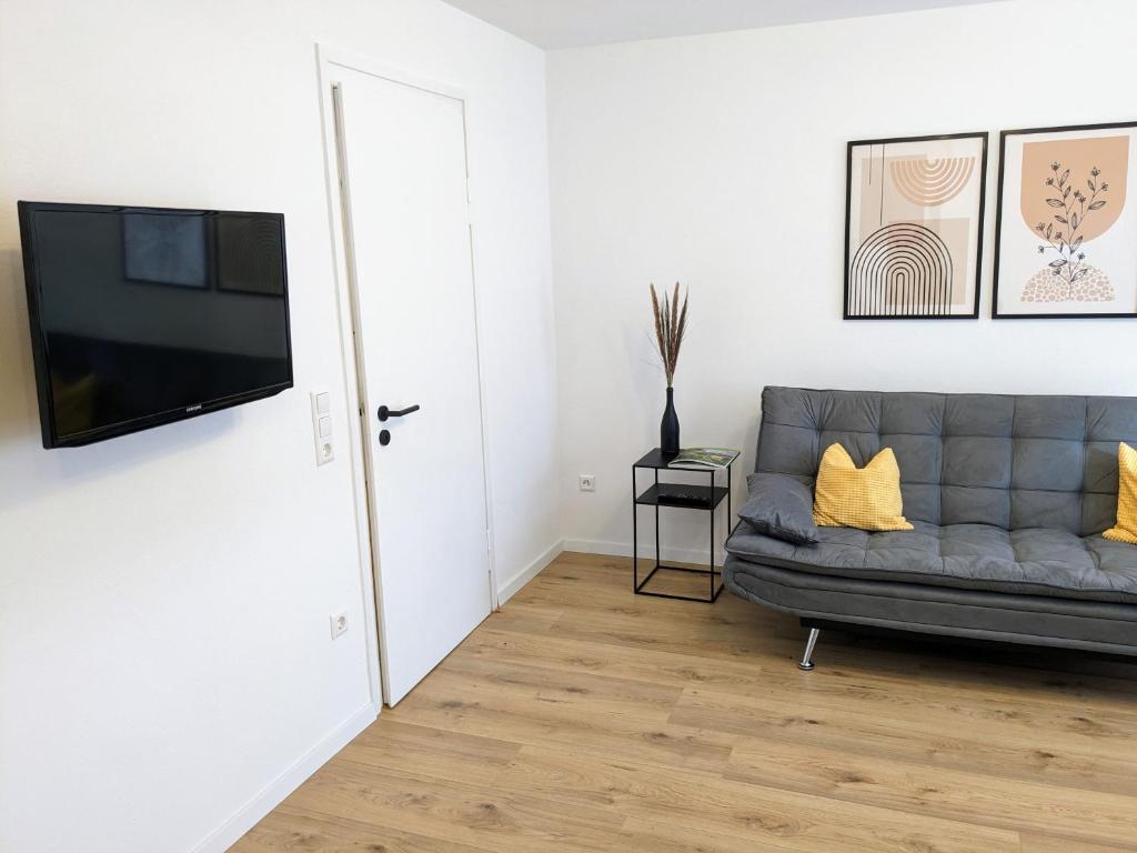 a living room with a couch and a flat screen tv at Ferienwohnung am Alenberg in Münsingen