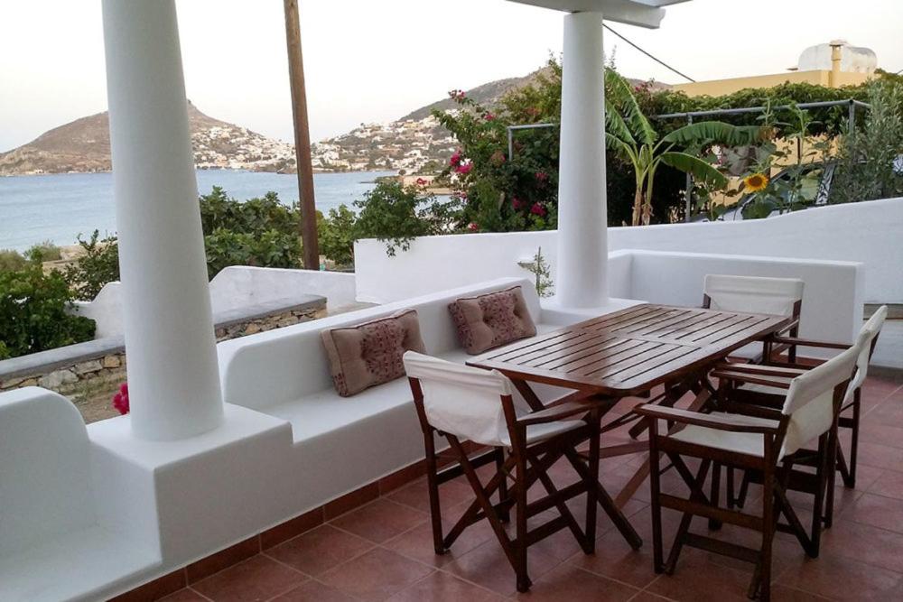 un tavolo e sedie su un balcone con vista sull'oceano di ALTHEA HOUSES ad Alinda