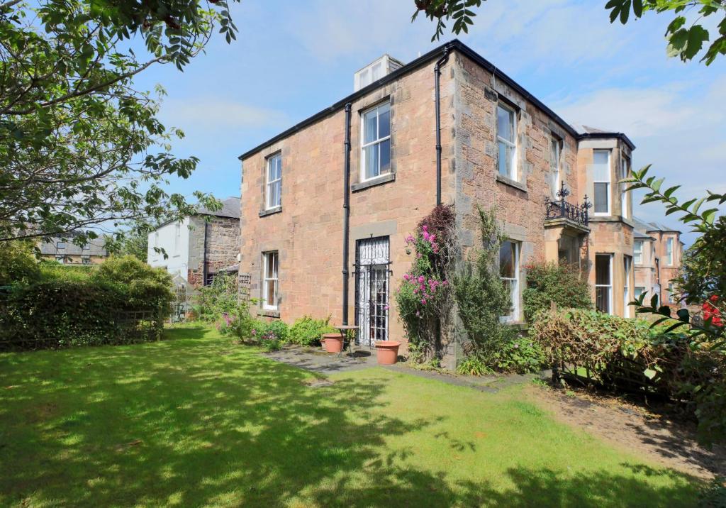 an old brick house with a green yard at Westend Place in North Berwick