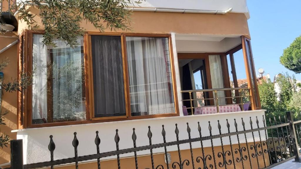 une maison avec un balcon et une clôture dans l'établissement Altınoluk 2 oda salon denize 50 m, à Edremit