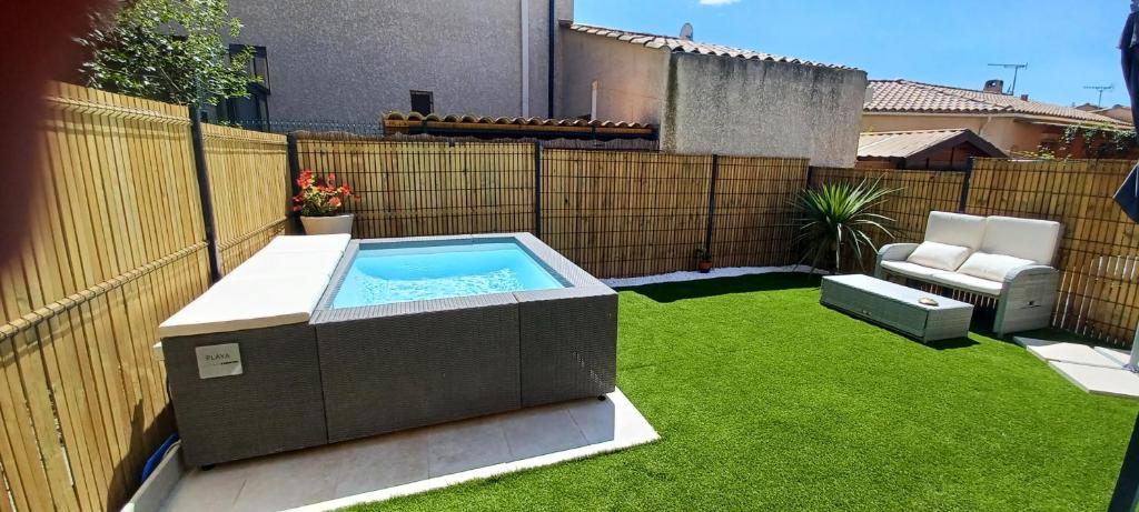 une cour avec un bain à remous sur la pelouse dans l'établissement Villa l ÉCRIN au cœur des alpilles, à Mouriès