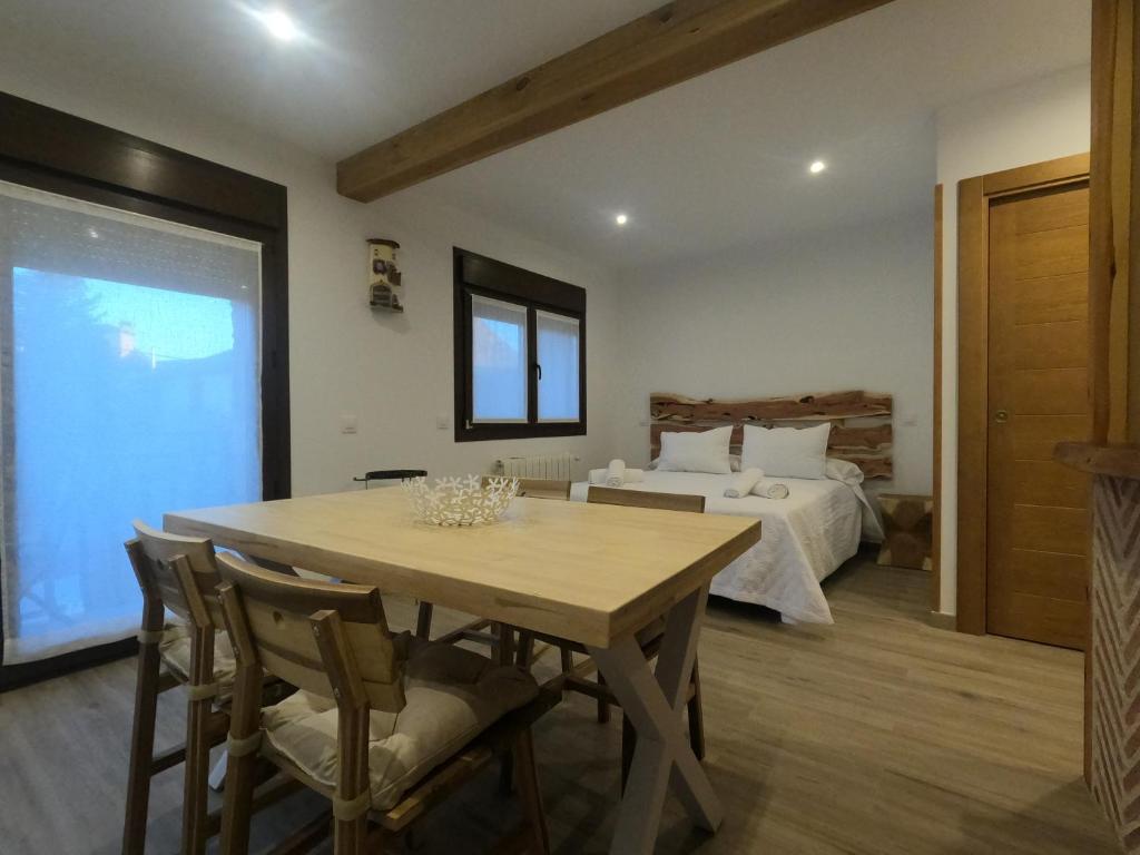 - une salle à manger avec une table et un lit dans l'établissement Apartamentos Sierra y Mar Aldealengua de Pedraza, à Ceguilla