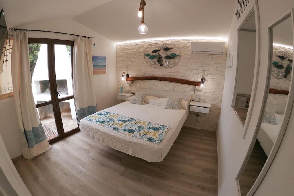 a small bedroom with a bed and a window at Oasi del Relax - Seaside Peaceful Panoramic Terrace in ITALY - new Sardinia apartment 50 mt beach&sea full comfort air conditioning-WiFi-Parking-Privacy in Torre Dei Corsari