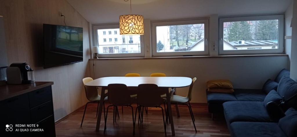 a living room with a table and chairs and a couch at Apartment na Gruszy in Stronie Śląskie