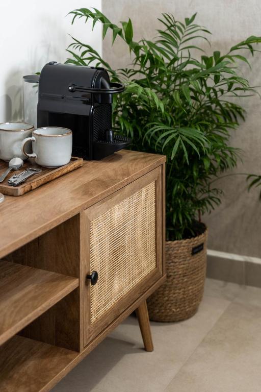a coffee maker on a wooden table next to a plant at KOYO Athens in Athens