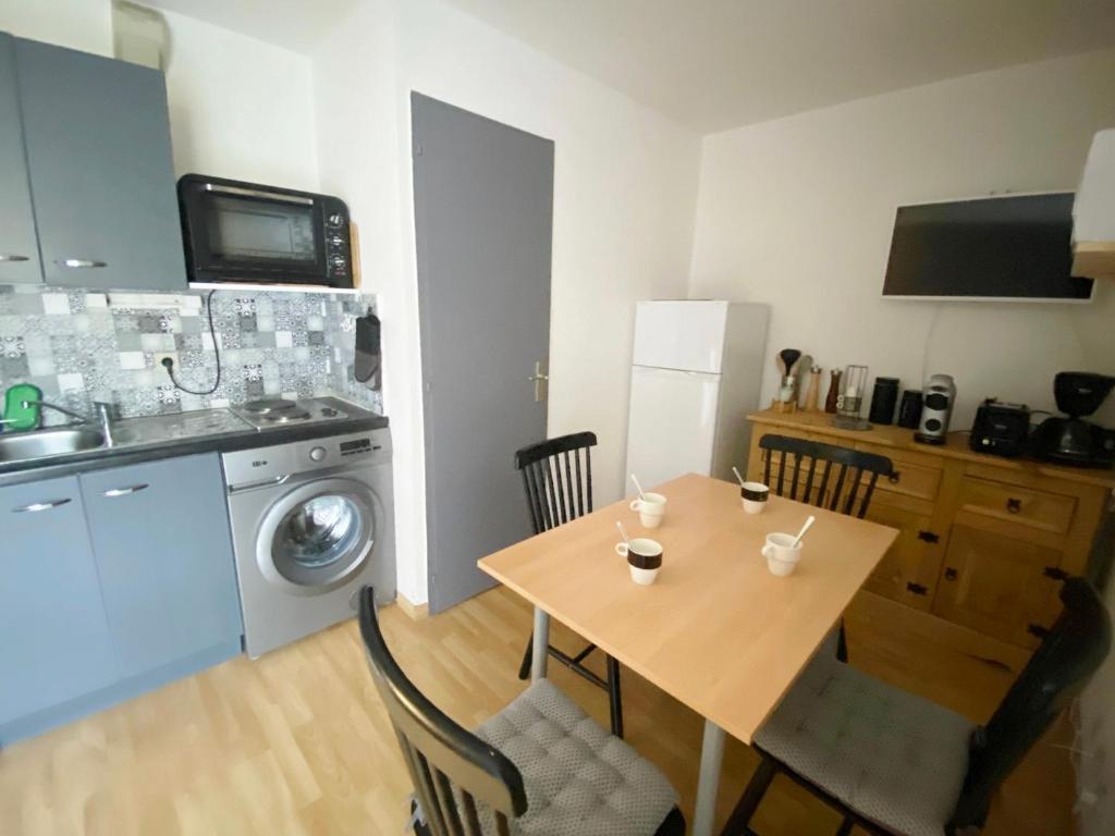 a kitchen with a wooden table and a kitchen with a washing machine at Appartement Morillon 1100, 2 pièces, 4 personnes - FR-1-412-87 in Morillon