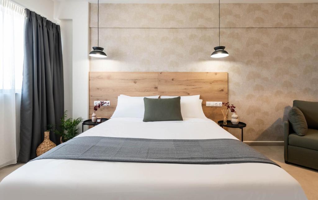 a bedroom with a large white bed and a chair at KOYO Athens in Athens