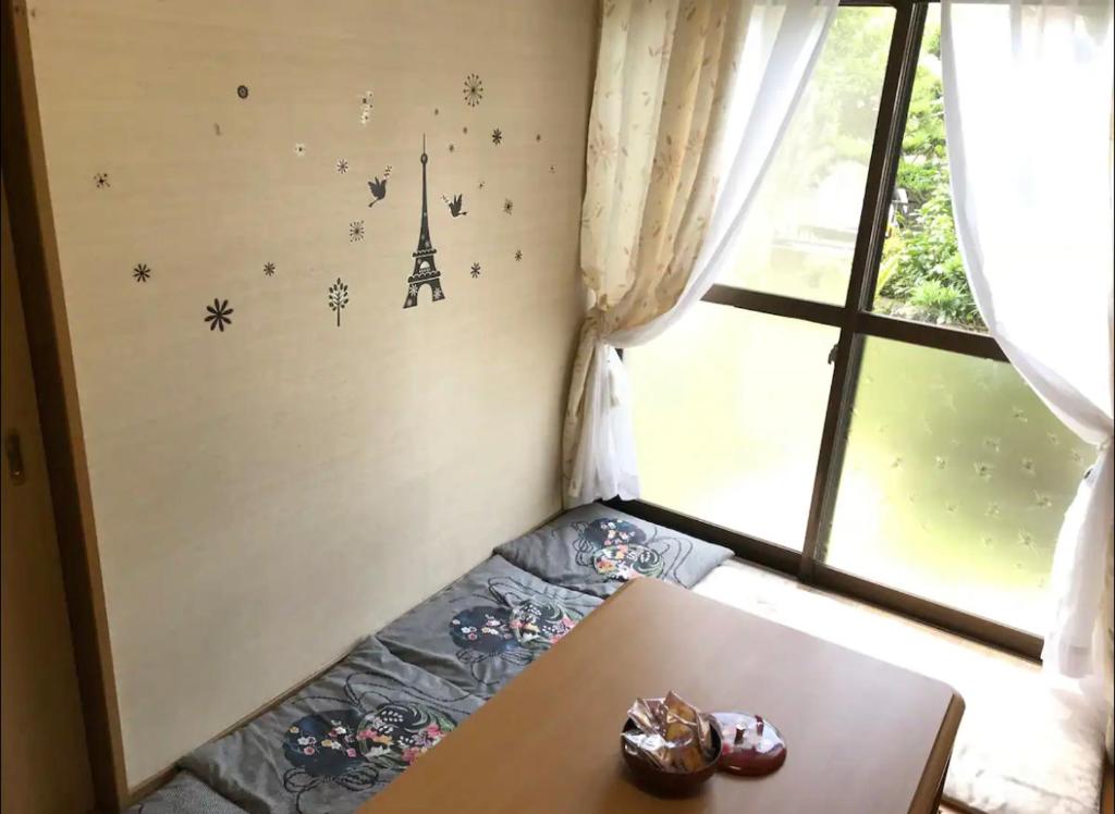Habitación pequeña con mesa y ventana en TOMO HOUSE en Taketoyo