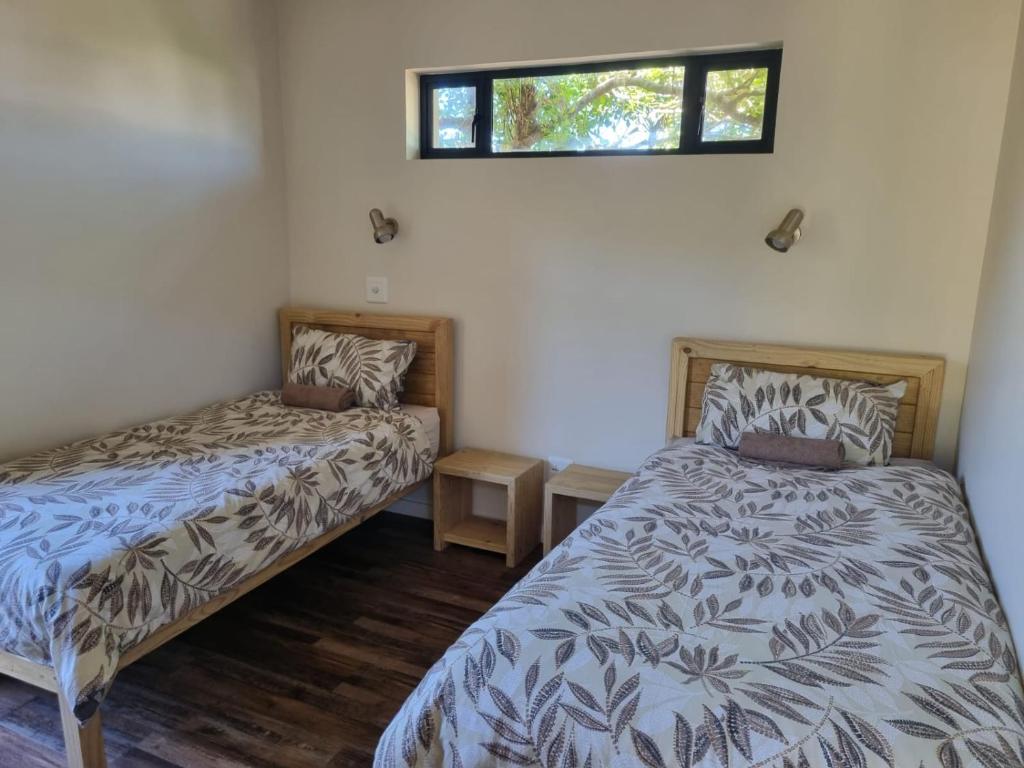 1 dormitorio con 2 camas y ventana en Let the good times roll-with inverter and wifi, en Cape St. Francis