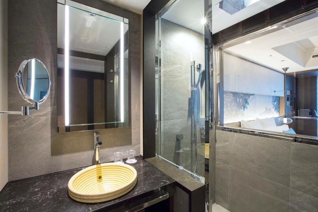 a bathroom with a sink and a shower with a mirror at Dhawa Yura Kyoto - Banyan Group in Kyoto
