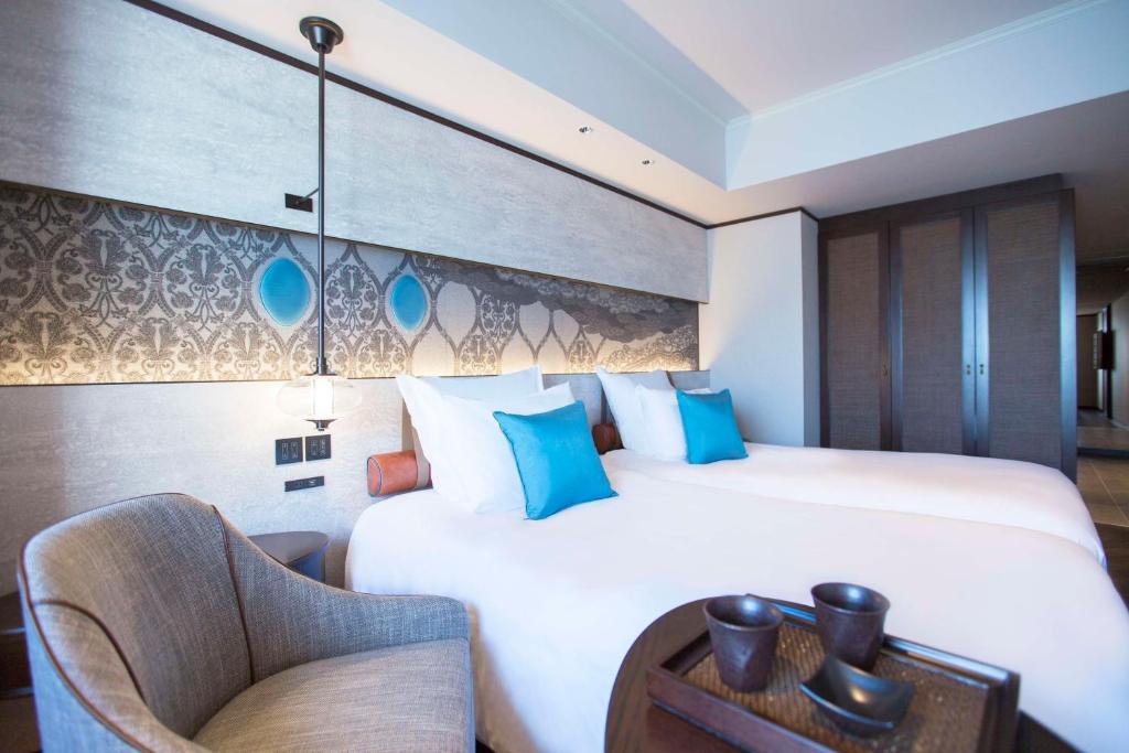 a hotel room with a large bed and a chair at Dhawa Yura Kyoto - Banyan Group in Kyoto