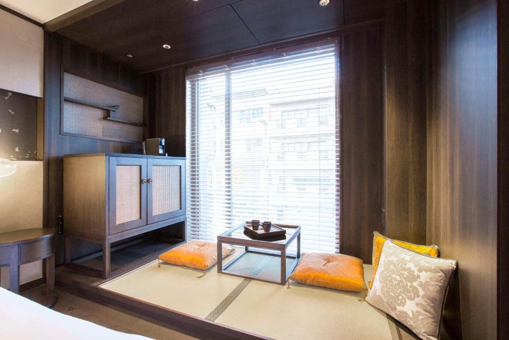 a bedroom with a bed and a table and a window at Dhawa Yura Kyoto - Banyan Group in Kyoto