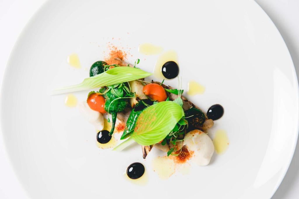 a plate of food with vegetables on a white plate at Dhawa Yura Kyoto - Banyan Group in Kyoto