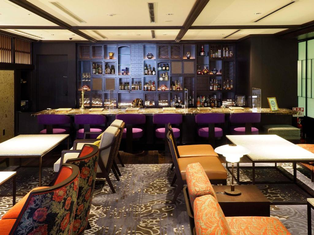 a restaurant with a bar with purple chairs and tables at Dhawa Yura Kyoto - Banyan Group in Kyoto