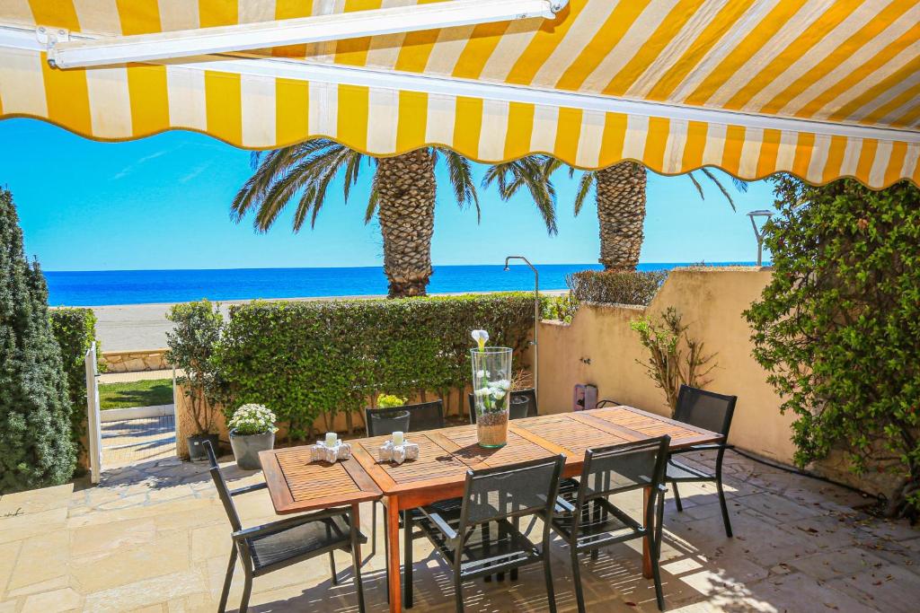 a patio with a table and chairs and the beach at Porto Fino Litoral - ONLY FAMILIES in Miami Platja