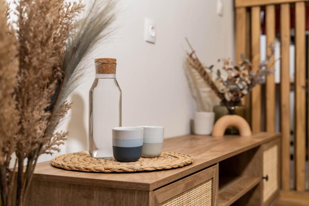 a bottle and two cups on a wooden table at KOYO Athens in Athens