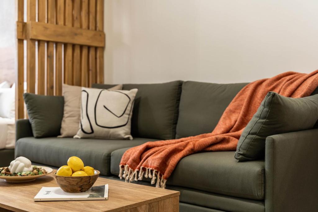 a living room with a green couch and a table at KOYO Athens in Athens